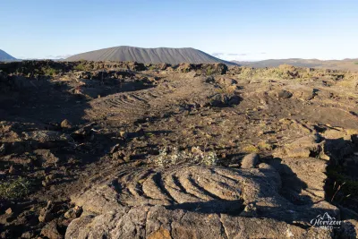Dimmuborgir, le cratère de Hverfjall au loin Dimmuborgir, le cratère de Hverfjall au loin