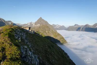 Abri Egilbu situé au sommet de Klokksegga, Slogen sur la gauche et mer de nuage sur le Hjørundfjord Abri Egilbu au sommet de Klokksegga