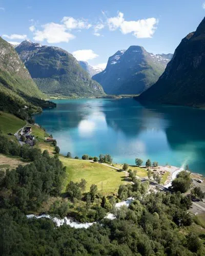 Vallée de Lodalen et lac Lovatnet aux eaux turquoise entouré de montagnes verdoyantes, Norvège